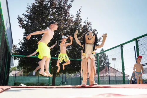 Maskot Svetluška s deťmi na trampolíne 